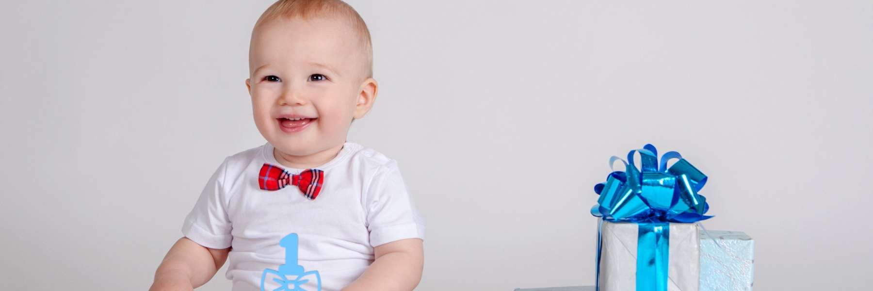 Baby Smiling next to gift | Castle Rock Dentist