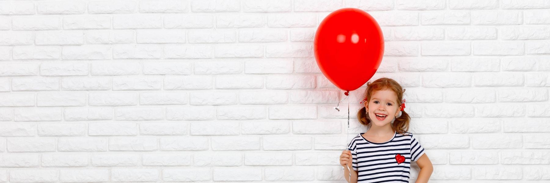 pediatric sedation dentistry | young girl holding a red balloon